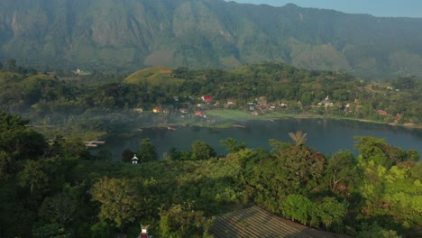 Aerial-drone-footage-of-cliffs,-resort-hotels,-and-villages-along-the-shoreline-of-Lake-Toba-in-North-Sumatra,-Indonesia