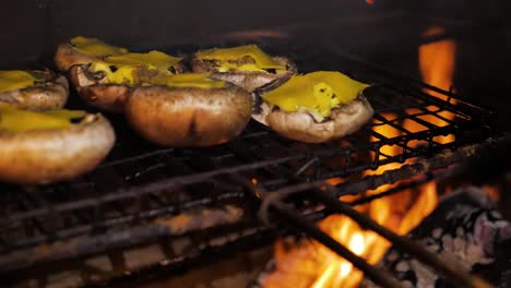 Mushrooms-with-garlic-butter---cheese-barbecued-on-open-fire,-panning-shot