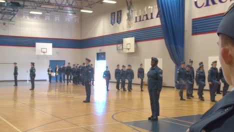 Canadian-Air-Cadets-await-command-to-fall-in-to-the-squadron's-main-formation,-watching-other-flights-form-in-front-of-an-audience