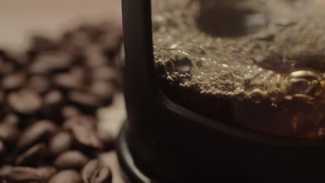 Pouring-fresh-coffee-into-a-pot-with-coffee-beans