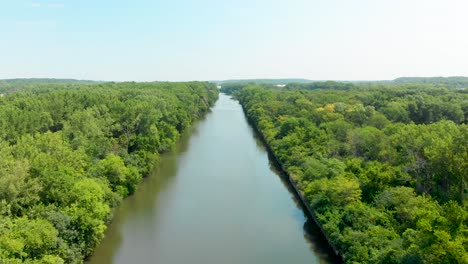 aerial-drone-toward-a-horizon-over-shipping-canal-and-blue-sky-4k