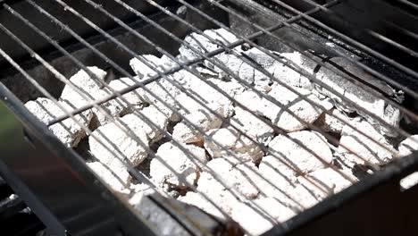 hot-charcoal-briquettes-with-empty-grill-above-in-sunlight-outdoors