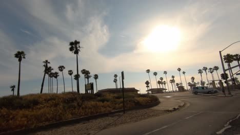 Sunset-drive-down-Pacific-Coast-Hwy-passing-palm-trees-and-shore-line-on-the-Huntington-Beach-coast