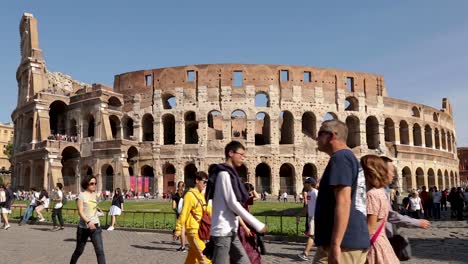 Stabile-Aufnahme-Mit-Wunderschönem-Blick-Auf-Das-Berühmte-Kolosseum,-Während-Viele-Menschen-In-Der-Stadt-Rom,-Italien,-Vorbeigehen-Und-Fotos-Machen