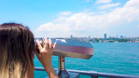 Slow-motion:beautiful-girl-looks-through-sightseeing-binoculars-on-Bosphorus,a-popular-destination-in-Uskudar,Istanbul,Turkey