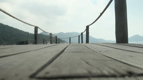 Close-up-of-a-wooden-walkway-on-an-island-in-Thailand,-pulling-focus-from-foreground-to-background