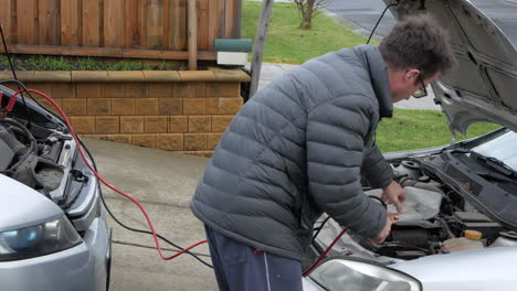 Man-creates-sparks-with-jump-leads-then-attaches-jump-cables-to-the-battery-of-a-car