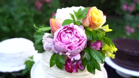 Colorful-Bouquet-of-Flowers-and-Roses-Adorning-Wedding-Cake-of-an-Outdoor-Wedding-Reception-in-Slow-Motion