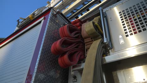 Fire-hoses-on-a-shiny-fire-engine-at-sunrise-outside-of-a-fire-station