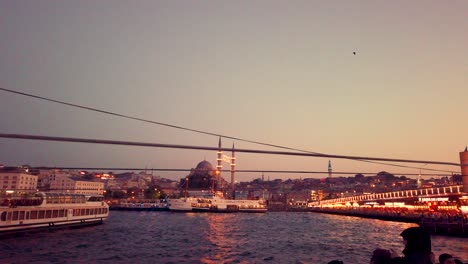 Slow-motion:Unidentfied-people-have-Istanbul-boat-tour-with-view-of-bosphorus-and-New-Mosque-at-sunset-in-istanbul,Turkey