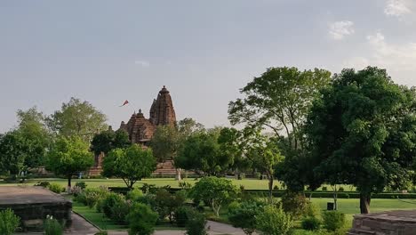 Un-Grupo-De-Templos-Occidentales-De-Khajuraho-Con-Hermosos-Jardines-Verdes-Y-Esculturas-Eróticas