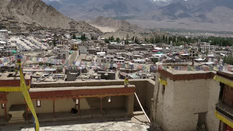 the-leh-city-with-house-made-of-mud-and-local-materials-crowded-the-Buddhist-flag-fluttering-due-to-winds-view-from-leh-palace