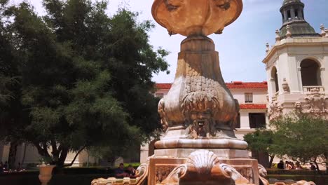 Pull-back,-low-profile-shot,-of-water-fountain,-in-courtyard-at-City-Hall,-Pasadena-California,-on-a-sunny-day