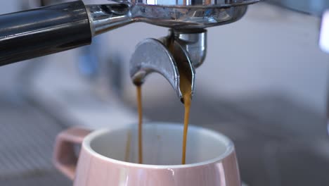 Frischer-Kaffee,-Der-Aus-Der-Kaffeemaschine-Im-Café-In-Eine-Tasse-Gegossen-Wird,-Nahaufnahme