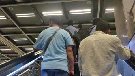 group-of-people-climbing-on-escalator-in-airport-metro-station-in-terminal-3-international-airport