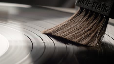 Hand-removing-dust-from-a-vinyl-record-with-antistatic-brush
