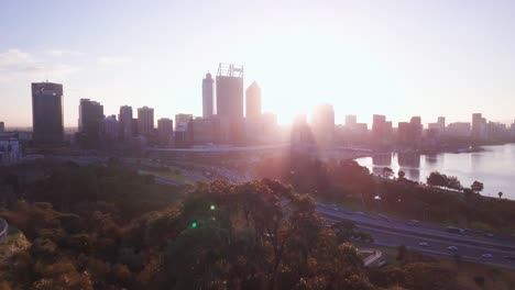 Luftaufnahme-Der-Skyline-Von-Perth-Bei-Sonnenaufgang-Mit-Lichtstrahlen-Und-Vorwärtsbewegung-Der-Kamera