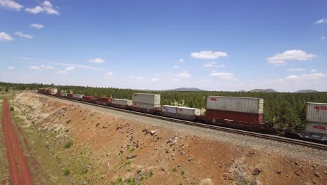 Aerial-train-engine-pulls-colorful-cargo-cars-along-the-parallel-tracks-near-Williams-Arizona