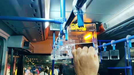 Close-up-of-hands-of-people-holding-air-bus-handle-in-an-indigo-bus-while-their-onward-journey-to-board-a-flight