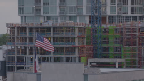 American-flag-and-Texas-flag-flying-in-front-of-construction-site-in-Austin,-Texas