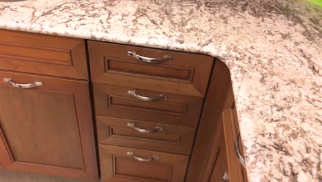 Traditional-wooden-kitchen-cabinets-with-slow-motion-closing-of-the-kitchen-drawer,-hand-of-person-visible