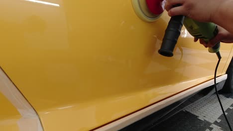 Das-Panel-Des-Gelben-Supersportwagens-Wird-Mit-Einer-Rotationsmaschine-In-Zeitlupe-Poliert