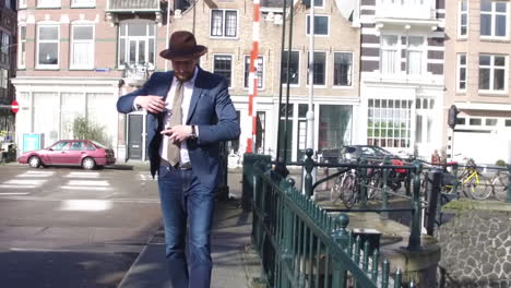 Un-Hombre-Elegante-En-Estilo-Dandy-Con-Barba-Hace-Una-Llamada-Telefónica-En-Un-Puente-En-Amsterdam