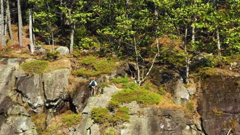 Luftaufnahmen-Der-Umlaufbahn-Um-Einen-Einsamen-Bergsteiger-Auf-Der-Spitze-Einer-Klippe-In-Maine