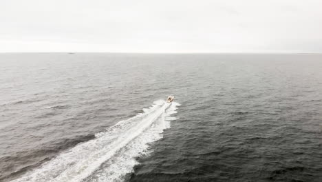 Aerial-shot-of-one-lone-motor-boat-speeding-through-the-endless-waves-of-the-open-ocean