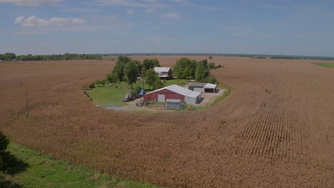 Aerial-of-a-barn,-farm,-and-homestead-in-farmland-in-the-midwest