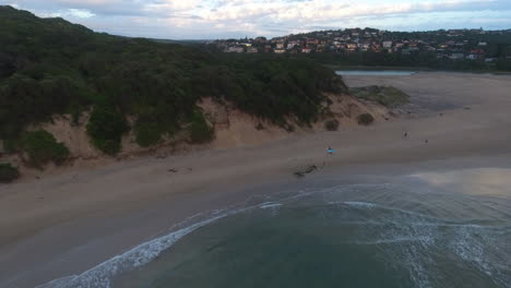 Cinematic-aerial-at-sunrise-of-surfers-along-coast-of-South-Africa-sport