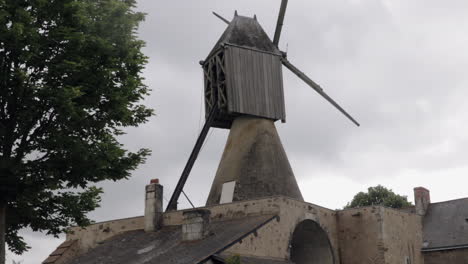 Old-vintage-windmill-in-french-country-side-on-field-under-cloudy-sky