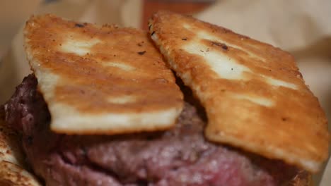 Sliced-and-grilled-halloumi-cheese-is-placed-atop-a-gourmet-hamburger