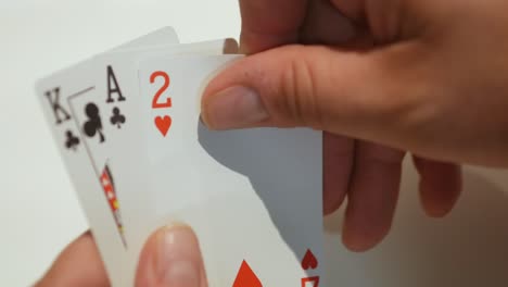 Close-up-of-a-card-player's-hands-picking-up-a-random-deal-of-playing-cards