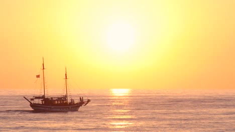 Ein-Boot,-Das-Bei-Sonnenuntergang-über-Unruhiges-Wasser-Auf-Dem-Offenen-Meer-Segelt