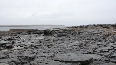 Flat-Rocky-Ocean-Shore-Line-on-Cloudy-Day-with-Rain