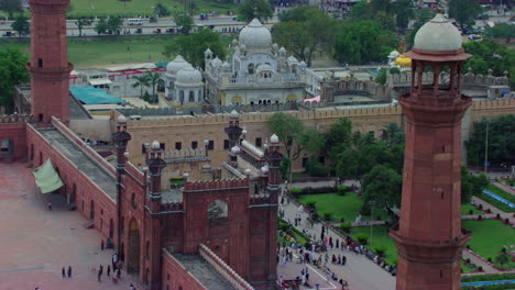 Lahore,-Pakistan,-Luftaufnahme-Der-Badshahi-Moschee-Bei-Den-Minaretten,-Zeigt-Gurdwara-Der-Sikhs,-Straßen--Und-Stadtverkehr,-Besucherinnen,-Damen,-Herren-Und-Kinder-Sind-In-Der-Moschee