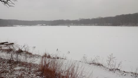 A-wide-shot-horizontal-pan-of-a-frozen-lake-in-rural-Illinois-during-a-passing-blizzard
