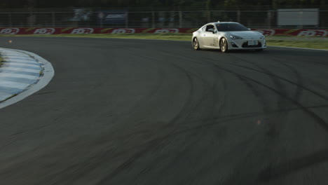 White-Race-Car-Driving-Around-a-Motor-Sports-Track