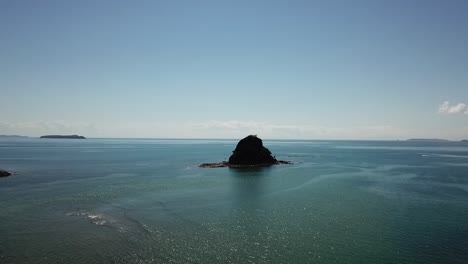 Insel-Im-Ozean-In-Der-Bay-Of-Islands,-Neuseeland-Mit-Einem-Schnellboot-Im-Hintergrund