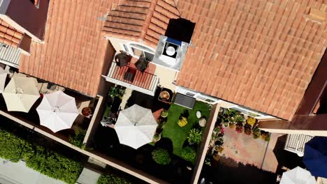 Aerial-rotation-straight-down-look-over-condo-backyards-with-umbrellas