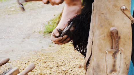A-farrier-nailing-a-freshly-made-shoe-onto-a-horses-foot