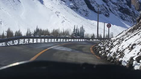 Driving-between-snowy-mountains-in-Cajón-del-Maipo,-Chile