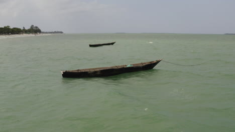 Two-wooden-fishing-canoe-boats-anchored-near-the-beach-side-near-Dar-es-Salaam,-Tanzania