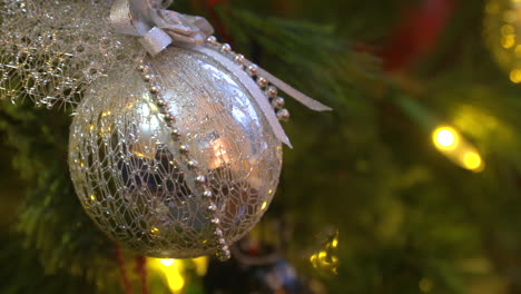 Rack-focus-close-up-of-a-silver-ornament-on-a-Christmas-tree
