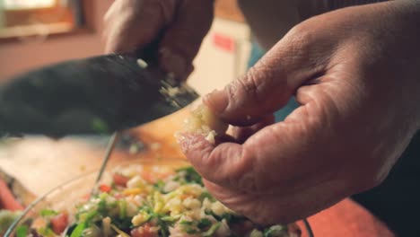Hände-Schließen-Sich-Und-Schneiden-Knoblauch-Mit-Einem-Messer-In-Sehr-Kleine-Stücke,-Um-Ihn-Dem-Salat-Hinzuzufügen