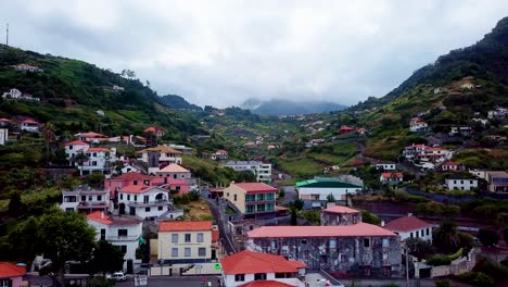 Aerial-shot-over-houses-towards-hill-Porto-da-Cruz,-Madeira,-Portugal