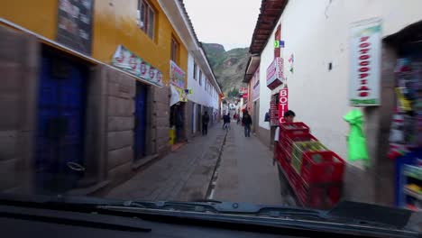 A-view-from-the-front-of-the-bus-driving-through-a-very-narrow-street-in-the-sacred-valley-in-Peru