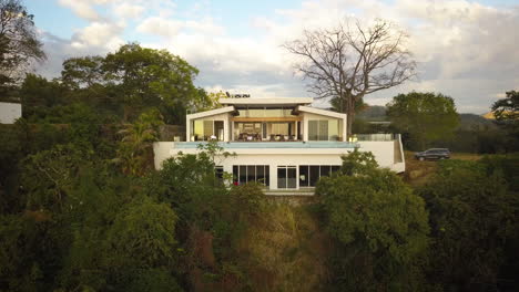 Exterior-of-a-large-modern-white-home-on-a-tropical-hillside