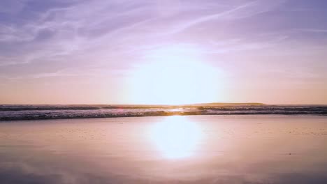 Ein-Atemberaubender-Und-Wunderschöner-Lila-Sonnenuntergang-Am-Meer,-Während-Die-Wellen-In-Zeitlupe-Rollen
